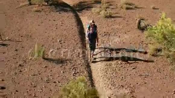 沙漠徒步旅行者在崎岖小径上的空中射击视频的预览图