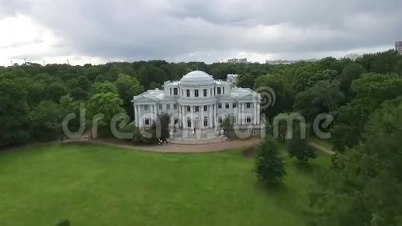 对在花园里的宫殿里跳舞的新娘和新郎进行空中勘察大白宫或城堡景观在空中飞行视频的预览图