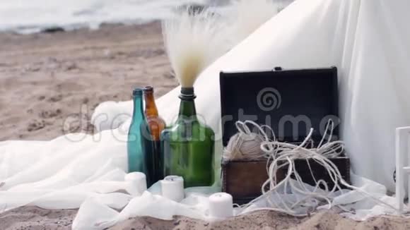 装饰瓶放在白色纸巾上上面有蜡烛一盒线海滩视频的预览图