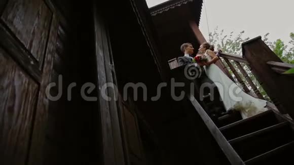 蜜月站在一座古老木屋的楼梯上视频的预览图