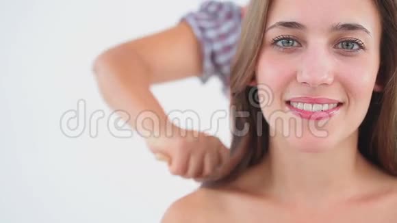 幸福的女人坐在她的头发刷的时候视频的预览图