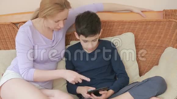 妈妈和她的儿子说得很好看着平板电脑触摸触摸屏视频的预览图