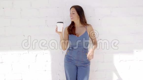 年轻女子正在享用一杯外卖咖啡视频的预览图