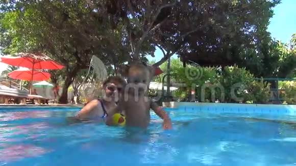 在一个游泳池里婴儿在相机里扔了一个黄色的球把透明的水喷到相机里慢动作视频的预览图