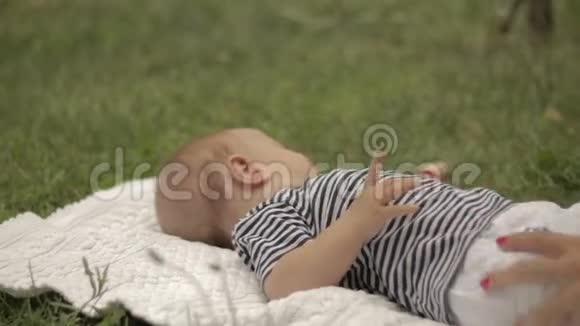 一个小孩子躺在草地上打滚视频的预览图