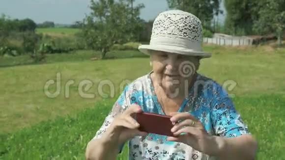 年龄大的女人在公园里拍照视频的预览图