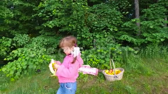女孩在夏天的森林里吃香蕉这个女孩在新鲜空气中有很好的食欲视频的预览图