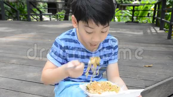 年轻的亚洲可爱男孩在泡沫盒里吃炸辣面视频的预览图