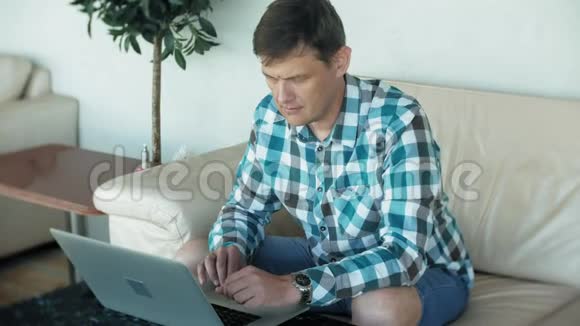 商人坐在沙发上桌上放着平板电脑看着报纸视频的预览图