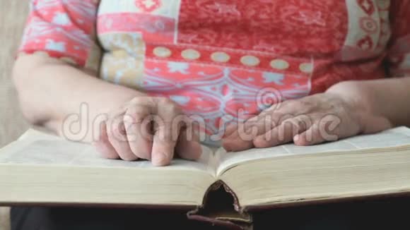 老妇人在读厚厚的书页视频的预览图