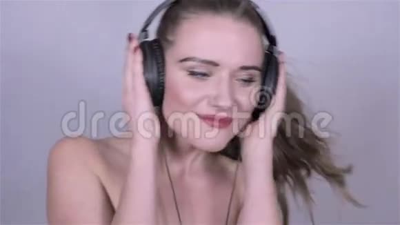 戴着耳机在演播室跳舞的年轻美女视频的预览图