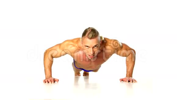 英俊的肌肉男在白色上做俯卧撑视频的预览图