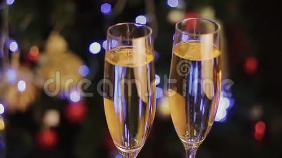 背景明亮的圣诞装饰品和两个香槟酒杯视频的预览图