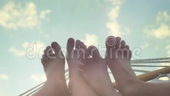 年轻的两只脚在吊床上休息在天空的背景下运动1920x1080高清高清视频的预览图