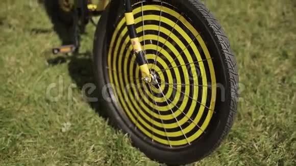 观看黑色和黄色创意自行车停留在绿草上夏季节日晴天视频的预览图
