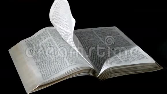 圣经书页在黑色背景下随风而逝视频的预览图