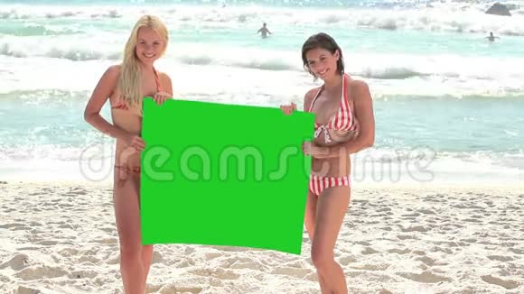 两个女人拿着绿色的屏幕视频的预览图