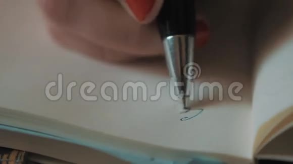 用钢笔在普通笔记本上用红色指甲油书写的女人手视频的预览图