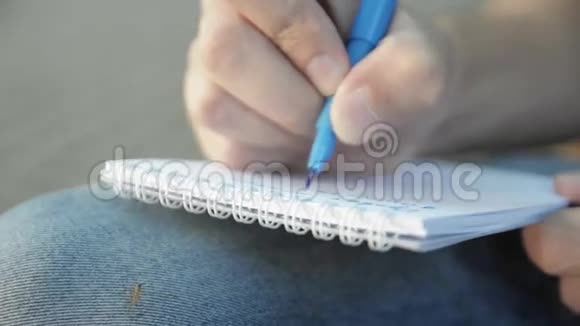 男人用蓝色记号笔在纸笔记本上写东西小蚊子视频的预览图