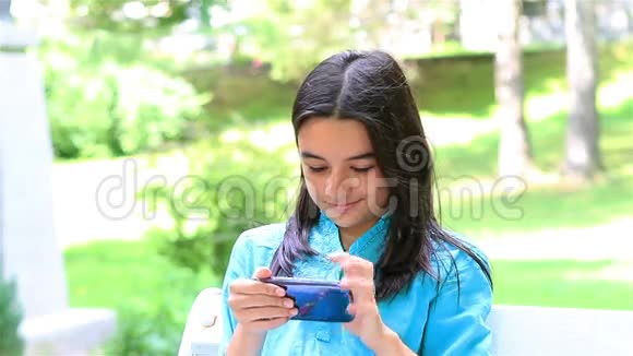 十几岁的女孩在玩智能手机视频的预览图