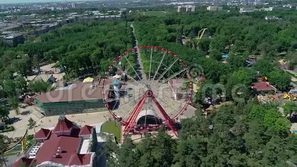 公园内摩天轮鸟瞰一个巨大的摩天轮在一个绿色公园的中央与无人机拍摄视频的预览图