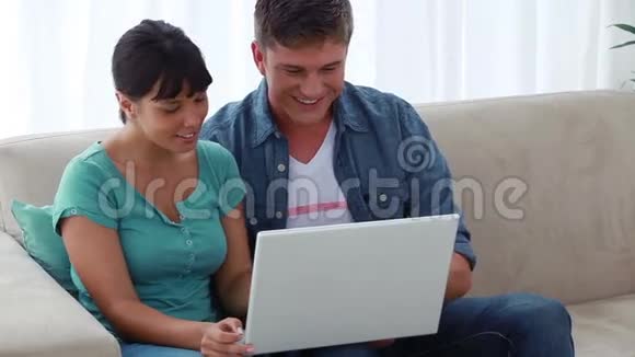 快乐的一对夫妇在看他们的个人电脑视频的预览图