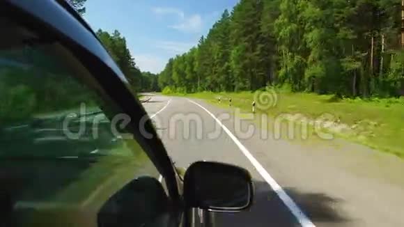 波夫在阳光明媚的日子里汽车正在俄罗斯阿勒泰的一条高速公路上穿过树林视频的预览图