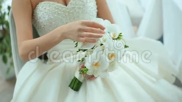 美丽的新娘捧着白色的婚礼花束新娘饰品婚姻详情视频的预览图