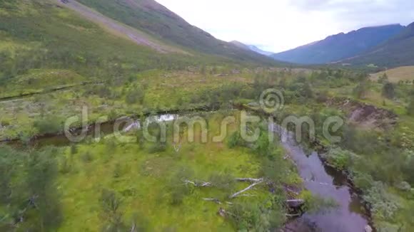 飞过一条小溪和树木在高山之间视频的预览图