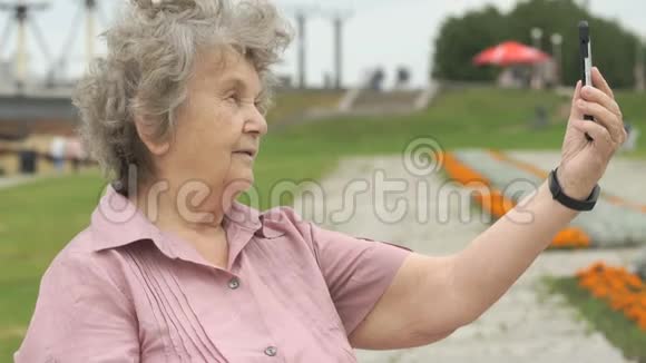 老年妇女使用手机拍照视频的预览图