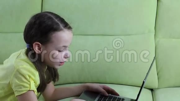 漂亮的小女孩在笔记本电脑上聊天和打字视频的预览图