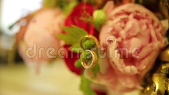 结婚戒指和粉红色玫瑰花束婚礼花束上的结婚戒指玫瑰花束上的结婚戒指视频的预览图