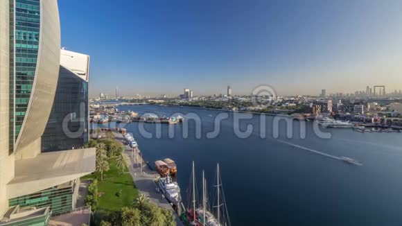 在日落时迪拜小溪的景观随着船只和船只在港口和现代建筑的背景而逐渐消失视频的预览图