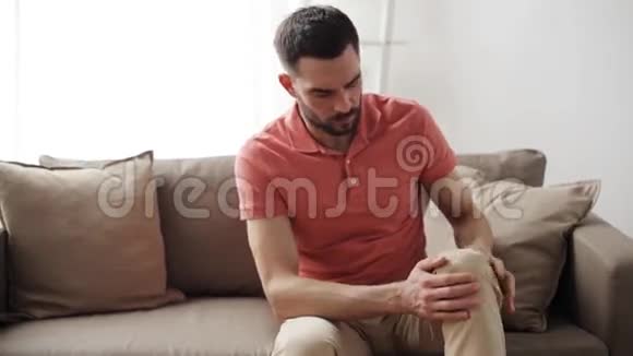 不高兴的男人在家里腿疼视频的预览图
