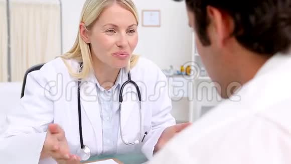 微笑的金发医生在和她的病人说话视频的预览图
