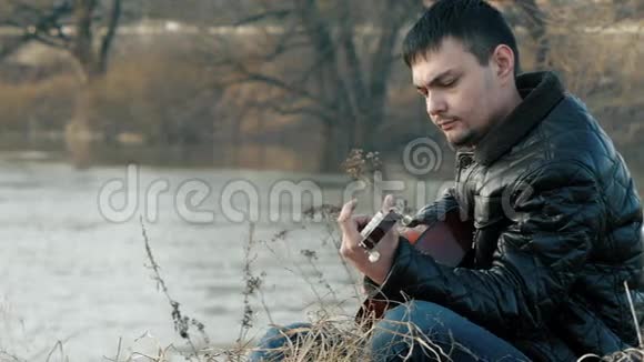 在河边弹吉他的年轻人视频的预览图