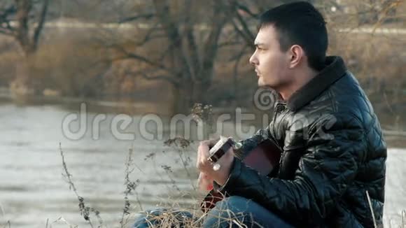 在河边弹吉他的年轻人视频的预览图
