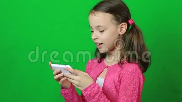 可爱的小女孩手里拿着智能手机视频的预览图