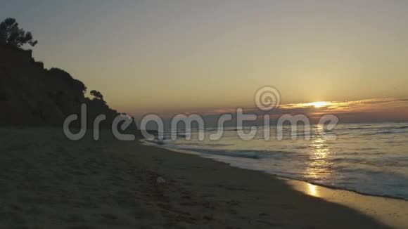 在寂静的夕阳下海浪在沙滩上翻滚海洋平静概念视频的预览图