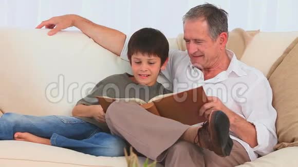 一位祖父和他的孙子在看专辑视频的预览图