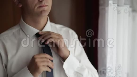 英俊的新郎系好领带结婚的早晨商人慢动作视频的预览图