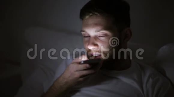 有智能手机的男人晚上用录音机视频的预览图