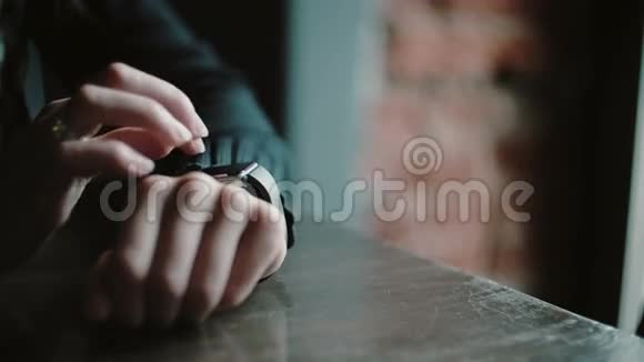 双手特写使用智能手表触摸屏设备的妇女在阁楼咖啡馆4k视频的预览图