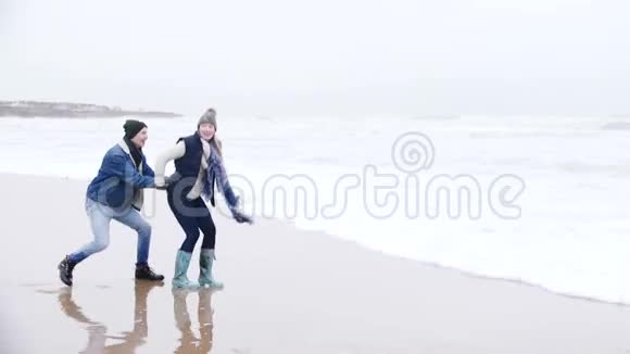 年轻的夫妇在冬天的海上大笑视频的预览图