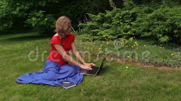 孕妇看着笔记本电脑写在纸笔记本上视频的预览图