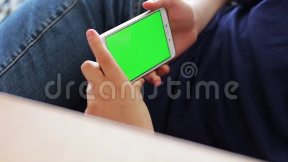 在家里的沙发上使用智能手机色键上网的青少年视频的预览图