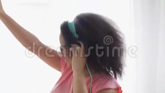 戴着耳机在家跳舞的快乐非洲女人视频的预览图