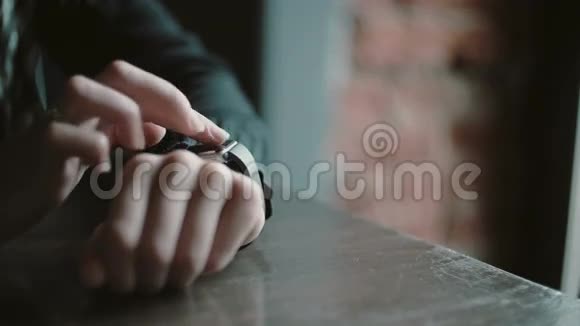 双手特写使用智能手表触摸屏设备的妇女在阁楼咖啡馆4k视频的预览图