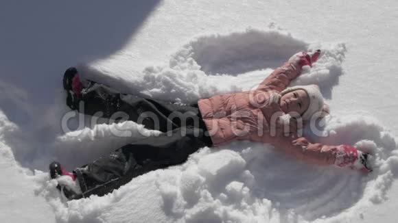 美丽的小女孩做雪天使视频的预览图