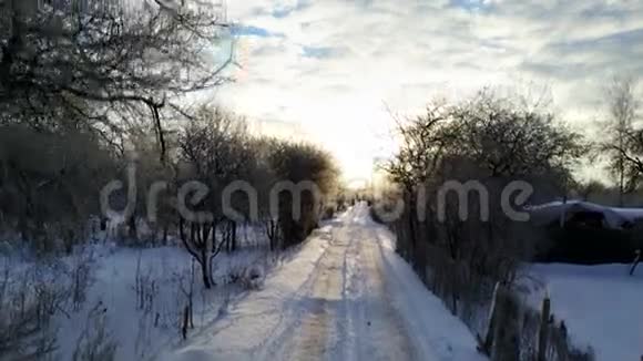 鸟瞰日落时在覆盖着雪的道路上方飞行视频的预览图